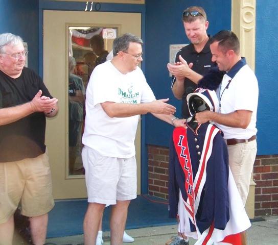 Marching Illini director Barry Houser (far right) donated Illini band uniform made by DeMoulin Bros. & Co.