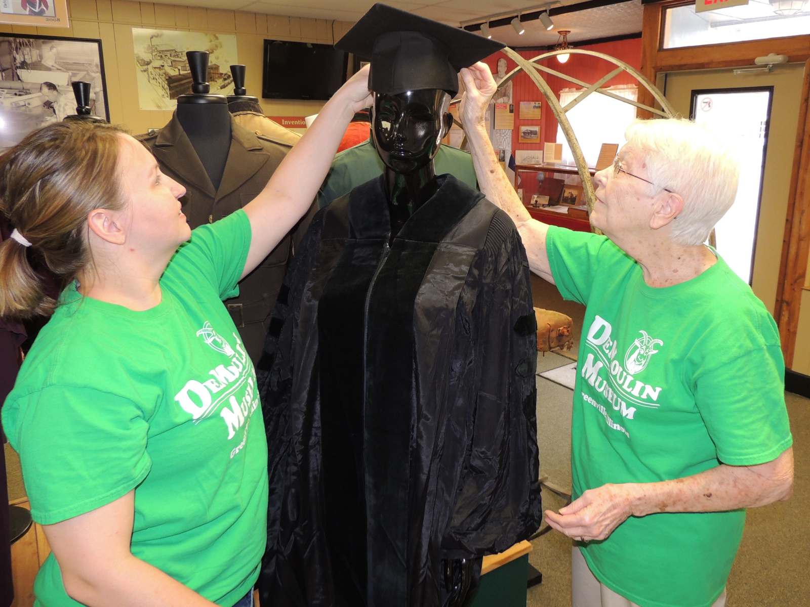 DeMoulin Museum volunteers prepare Ruby Dee’s doctoral gown for display.